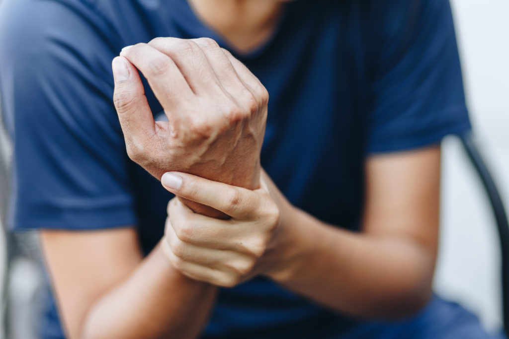 Person holding wrist from achy joints